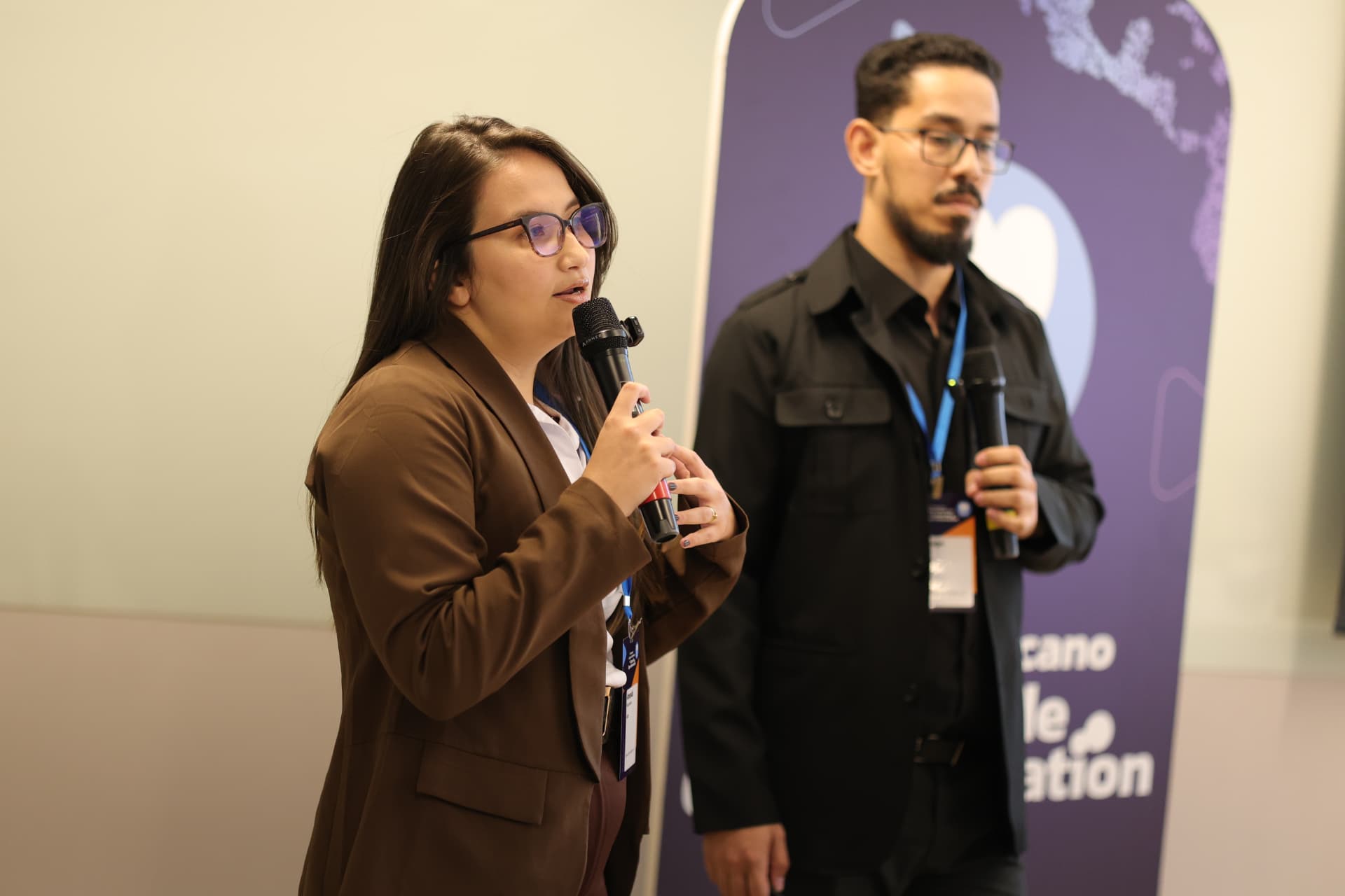 Olos e Beedoo apresentando o case em conjunto no palco do congresso